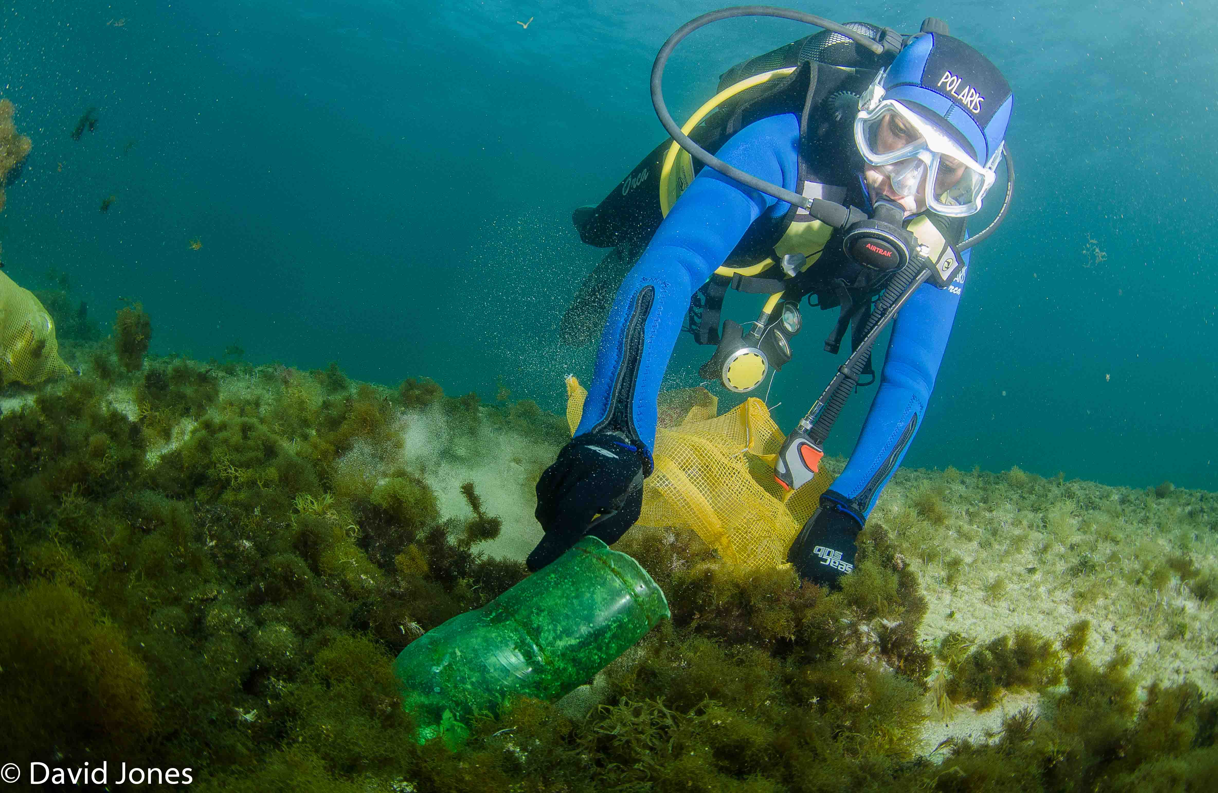 Diver picking up a plastic bottle